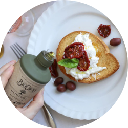 Bottle of olive oil above plate with dish